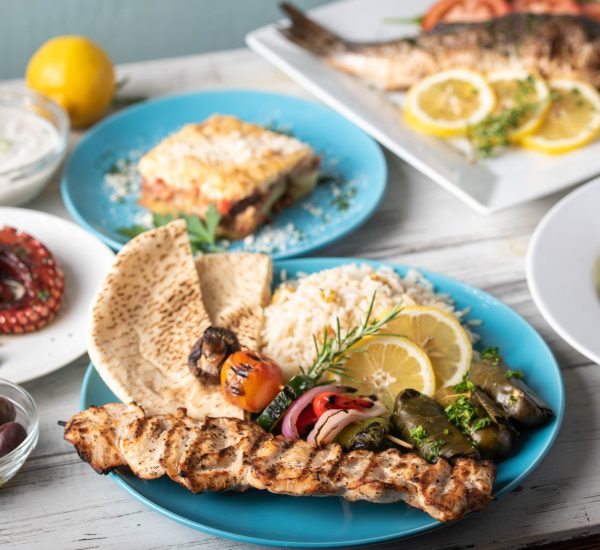 assorted popular greek plates on rustic wooden background